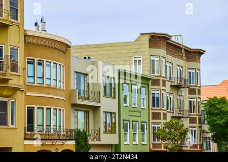 Fila di case e condomini affiancati da scale antincendio all'estremità e finestre a bovindo Foto Stock