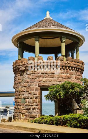 Lyfords Stone Tower con cipresso accanto sotto il cielo blu nuvoloso in estate Foto Stock