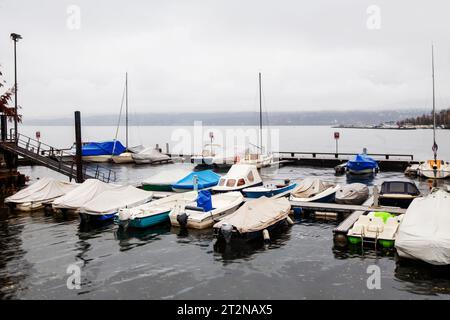 Parcheggi con piccoli motoscafi sul lago maggiore vicino alla riva del centro di Locarno. La nebbia nasconde le Alpi svizzere. L'autunno arriva nella Svizzera meridionale Foto Stock