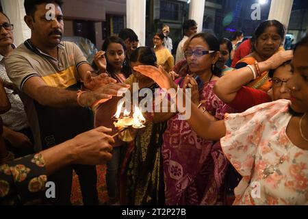 Kolkata, India. 20 ottobre 2023. Rituali serali di culto comunitario annuale di più giorni della Dea indù Durga, dove i devoti indù prendono calore dal Pancha Pradip come benedizioni sull'auspicio Shashthi Tithi. La puja di Durga in autunno è il più grande festival indù annuale di più giorni del nord-est dell'India. (Foto di Biswarup Ganguly/ Pacific Press) credito: Pacific Press Media Production Corp./Alamy Live News Foto Stock