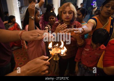 Kolkata, India. 20 ottobre 2023. Rituali serali di culto comunitario annuale di più giorni della Dea indù Durga, dove i devoti indù prendono calore dal Pancha Pradip come benedizioni sull'auspicio Shashthi Tithi. La puja di Durga in autunno è il più grande festival indù annuale di più giorni del nord-est dell'India. (Foto di Biswarup Ganguly/ Pacific Press) credito: Pacific Press Media Production Corp./Alamy Live News Foto Stock