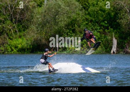 auburndale fl stati uniti 16 ottobre 2023. uomo che salta sul bordo del parco ronix un altro ragazzo che filma con gopro al parco cavi elite Foto Stock