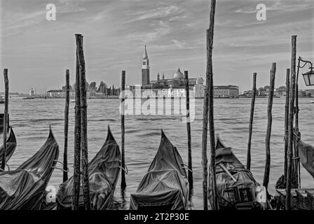 Fotografia in bianco e nero della Gondola ormeggiata al Molo San Marco di Venezia con San Giorgio maggiore sullo sfondo con spazio per la copia Foto Stock