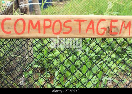 Semplice targhetta di identificazione realizzata a mano, in legno e vernice rossa, con la parola compostaggio scritta in portoghese brasiliano. Foto Stock