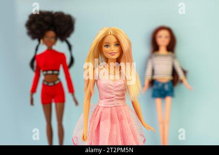 9 ottobre 2023. Barnaul, Russia: Tre bambole bionde, afroamericane e dai capelli rossi su sfondo blu. Barbie e i suoi amici. Foto Stock