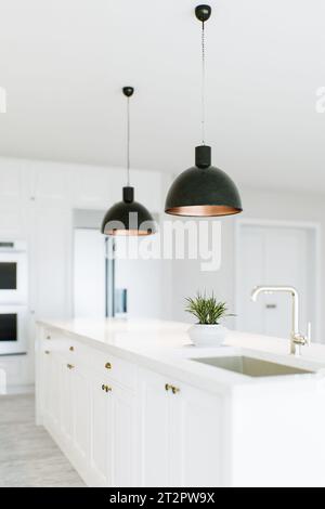 Vista dell'isola della cucina in una cucina bianca. Foto Stock