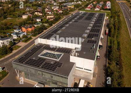 Fotografia con droni di grandi magazzini logistici e tetto di uffici con moduli di energia solare durante le giornate di sole autunnali Foto Stock