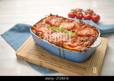 Lasagne, fresche dal forno, casseruola con fogli di pasta piatta, salsa di manzo macinata, verdure e pomodori, condita con formaggio fuso su un k di legno Foto Stock