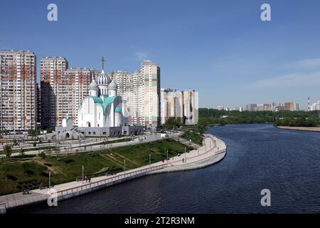 Vista della cattedrale di Nikolsky nella pianura alluvionale di Pavshinsky sull'ansa del fiume Mosca vicino agli edifici residenziali nella città di Krasnogorsk nelle giornate di sole Foto Stock