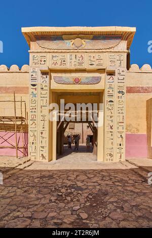 Ingresso all'antico tempio egiziano con scarabeo alato sopra la porta e due cobra e alcuni geroglifici. Foto Stock