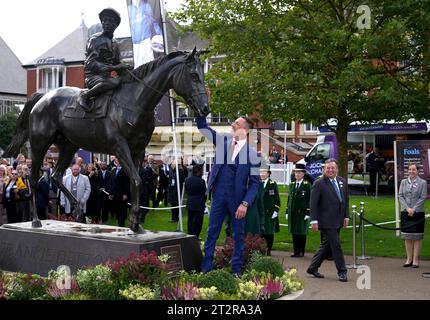 Jockey Frankie Dettori guarda una statua di sé stesso creata da Tristram Lewis dopo essere stata svelata dalla regina Camilla durante una cerimonia in vista del QIPCO British Champions Day all'ippodromo di Ascot, Berkshire. Data immagine: Sabato 21 ottobre 2023. Foto Stock