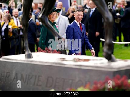 La regina Camilla e il fantino Frankie Dettori durante una cerimonia per svelare una statua creata da Tristram Lewis in vista del QIPCO British Champions Day all'ippodromo di Ascot, Berkshire. Data immagine: Sabato 21 ottobre 2023. Foto Stock