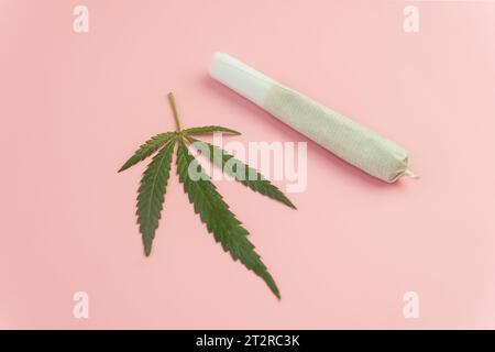L'attrezzatura fuma erba su sfondo rosa. Legalizzazione della cannabis. CBD e THC sulle gemme nella cannabis. Germogli di cannabis erbaccia su fondo di legno. Fumo di marijuana Foto Stock