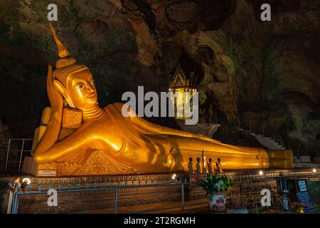 Splendido Buddha sdraiato dorato nella grotta del tempio Tumsar di Krabi, Thailandia. E' squisito e antico. Il tempio è in rovina, ma il Buddha è composto Foto Stock