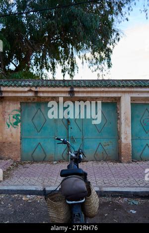 Scooter per strada di fronte a una vecchia porta Foto Stock