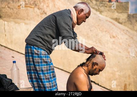 Vestirsi rituale per capelli ai ghati di Varanasi Foto Stock