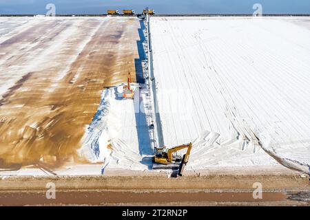 Huelva, Spagna - 21 ottobre 2023: Raccolta del sale negli evaporatori del sale marino nella riserva naturale Marismas del Odiel. Produzione tradizionale di sale marino Foto Stock