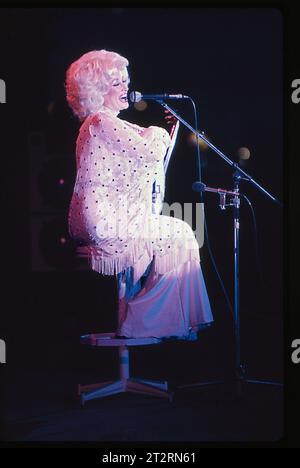 Un sorridente Dolly Parton fa una battuta al suo pubblico mentre tiene il banjo. Da qualche parte nel Midwest nell'estate del 1978. Foto Stock