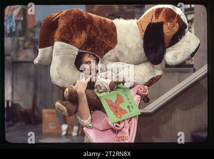 Una foto del 1977 del set di Sesame Street con l'attore Bob McGrath che interpretava Ben Johnson che faceva un volto con un grande cane imbottito sulla testa. In uno studio a Broadway nell'Upper West Side di Manhattan. Foto Stock