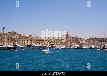 Vittoriosa, Malta - 17 giugno 2023: Porto di Vittoriosa con yacht e barche e la cupola della cattedrale sullo sfondo Foto Stock