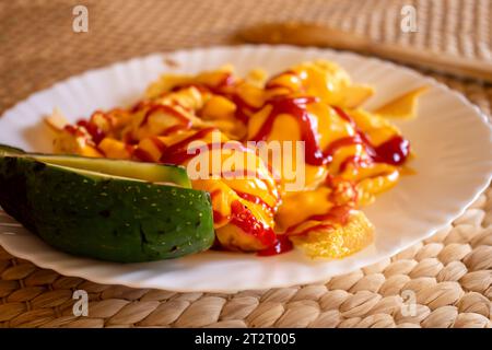 Uova e formaggio con salsa ketchup accanto a un po' di avocado Foto Stock