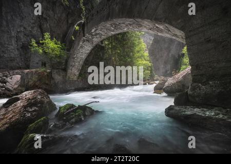 Un vecchio ponte in pietra sul torrente nell'Orrido di Pré Saint Didier, una veduta estiva di questo profondo burrone della Valle d'Aosta. Italia. Foto Stock