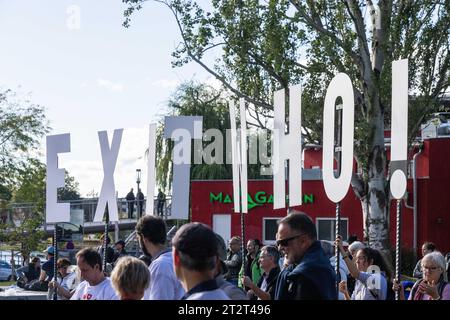 Weil am Rhein, Germania. 21 ottobre 2023. I partecipanti a una dimostrazione dal titolo "Demo per la pace, la libertà e la sovranità" si trovano nel Parco del Reno a Weil am Rhein e formano lo slogan "EXIT WHO!" con dei segni. Secondo la polizia, era difficile assegnare i partecipanti del raduno a uno spettro specifico. Tra gli altri, anche un politico AfD aveva tenuto un discorso. Secondo la polizia, i partecipanti alla controdimostrazione provenivano dallo spettro di sinistra. Credito: Philipp von Ditfurth/dpa/Alamy Live News Foto Stock