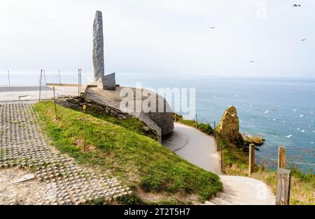 Il Pointe du hoc Ranger Monument, eretto sopra il bunker tedesco per la direzione di tiro, è un monolito di granito che simboleggia il pugnale dei Rangers. Foto Stock