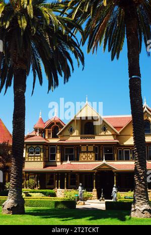 Due palme incorniciano la Winchester Mystery House, presumibilmente infestata, a San Jose, California Foto Stock