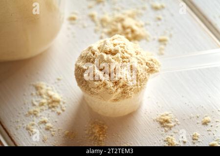 Una paletta di polvere di proteine di siero di latte su un tavolo luminoso Foto Stock