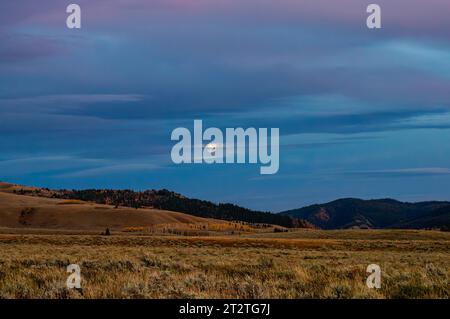 La luna sbircia tra le nuvole in una fresca notte autunnale a Jackson Hole, Wyoming. Foto Stock