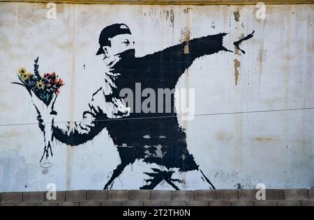 Il famoso murale di Banksy "Rage, the Flower Thrower (Love is in the Air)", dipinto su un autolavaggio in un sobborgo di Betlemme (Palestina) Foto Stock