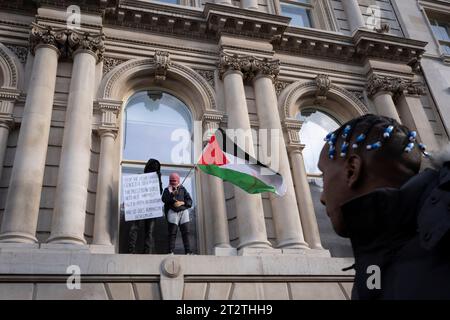 I manifestanti si trovano sulle corsie degli edifici governativi britannici a Whitehall mentre i pro-palestinesi marciano attraverso il centro di Londra per la seconda settimana consecutiva dopo gli attacchi di Hamas su Israele, il 21 ottobre 2023, a Londra, in Inghilterra. La polizia Met ha stimato che 100.000 hanno partecipato alla protesta attraverso la capitale, il secondo evento di massa di questo tipo in una settimana. Foto Stock