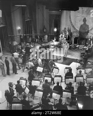 MAURICE CHEVALIER che filma LOVE ME TONIGHT 1932 con l'orchestra in studio sul palco sonoro dei Paramount Studios. Direttore ROUBEN MAMOULIAN da The Play di LEOPOLD MARCHAND e PAUL ARMONT Costume Design di TRAVIS BANTON e EDITH HEAD musica di RICHARD RODGERS e testi di LORENZ HART Paramount Pictures Foto Stock