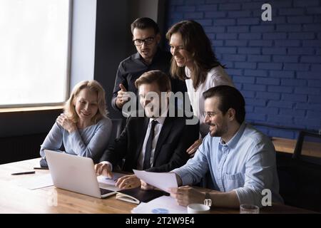 Un team aziendale felice lavora insieme al progetto con il laptop Foto Stock