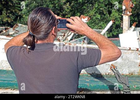 Erinnerung an die Flutkatastrophe 2021 Das erste Motorschiff Moornixe, das auf dem Namen Baldeney im Jahre 1933 getauft wurde und auf dem gleichnamigen Essener vedere Ausflugsschiff unterwegs War, trug zeitweilig den Namen Nixe und War eine Zeit lang in Ostfriesland. Nachdem das Schiff beim Hochwasser AM 15. Juli 2021 gesunken War, steht es heute kurz nach der Ankunft weitgehend unbeachtet und in einem völlig zerstörten Zustand nahe dem Spillenburger Wehr neben der Ruhr wo erste Besucher Handyfotos anfertigten. Essen Nordrhein-Westfalen Deutschland Westfalenstraße *** memoria dell'alluvione Foto Stock
