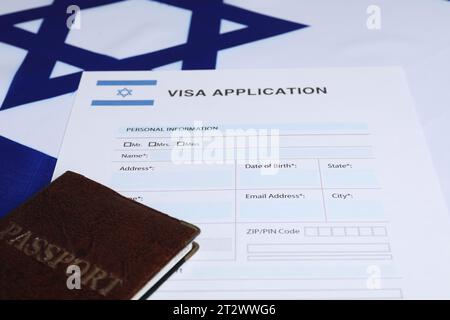 Immigrazione in Israele. Modulo di domanda di visto e passaporto sulla bandiera, primo piano Foto Stock