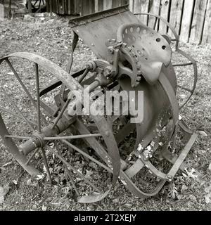 Un'immagine vintage in bianco e nero di un attrezzo agricolo con due grandi ruote a terra Foto Stock