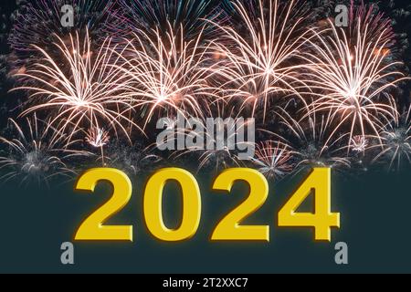 Testo d'oro 2024 che indica l'arrivo del nuovo anno sullo sfondo dei fuochi d'artificio festivi. Foto Stock