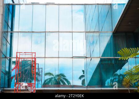 Spaziosa finestra dell'edificio con una scala rossa per la pulizia dei vetri in un edificio, dotata di ampio spazio per la copia dei testi Foto Stock