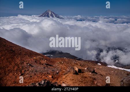 Paesaggio vulcanico di Kamchatka: Vista sulla cima del cono del vulcano Koryaksky dallo scenario del cratere attivo del vulcano Avacha nelle giornate soleggiate e nel cielo blu. Russo Foto Stock