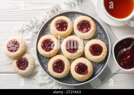 Primo piano sui biscotti Hallongrottor Swedish Thumbprint sul piatto sul tavolo di legno bianco. Vista superiore orizzontale dall'alto Foto Stock