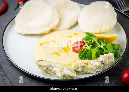 bistecca di pesce con torte di riso, pomodori ciliegini, limone ed erbe, vista laterale Foto Stock