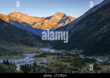 Valle alpina di Zemmgrund nelle Alpi dello Zillertal. La luce del sole all'alba su Gefrorene-Wand-Spitzen e Hoher Riffler. Tirolo. Alpi austriache. Europa. Foto Stock