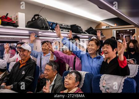 Pechino, provincia cinese dello Yunnan. 13 aprile 2023. I passeggeri si mettono in posa per una foto a bordo del primo treno passeggeri transfrontaliero da Kunming, nella provincia dello Yunnan della Cina sud-occidentale, fino alla capitale del Laos, Vientiane, il 13 aprile 2023. Credito: HU Chao/Xinhua/Alamy Live News Foto Stock