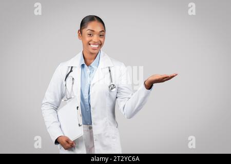 Allegro medico afro-americano adulto con clipboard per avere spazio libero a portata di mano Foto Stock