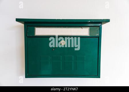 Cassetta postale verde vintage visualizzata su una parete bianca con composizione spazio copia per il testo Foto Stock