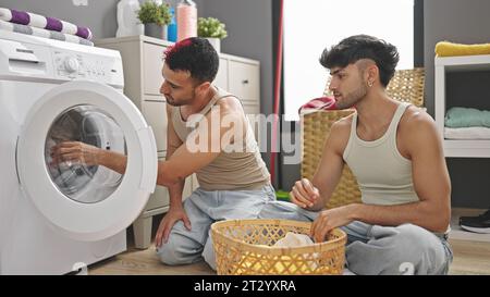 Due uomini si accoppiano a lavare i vestiti nella lavanderia Foto Stock