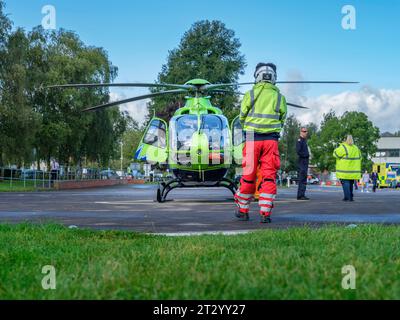 L'ambulanza Great Western Air si prepara per il decollo dall'esterno del Gloucester Royal Hospital. L'elicottero verde lime e blu brillante, cartello Hel Foto Stock