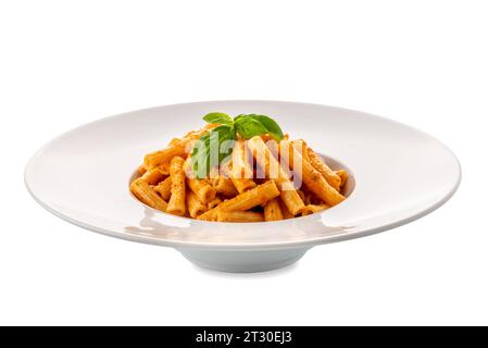 Macaroni rigati con salsa di pomodoro. Pasta italiana chiamata sedani rigati con pesto di pomodoro e foglie di basilico in piatto bianco isolato Foto Stock